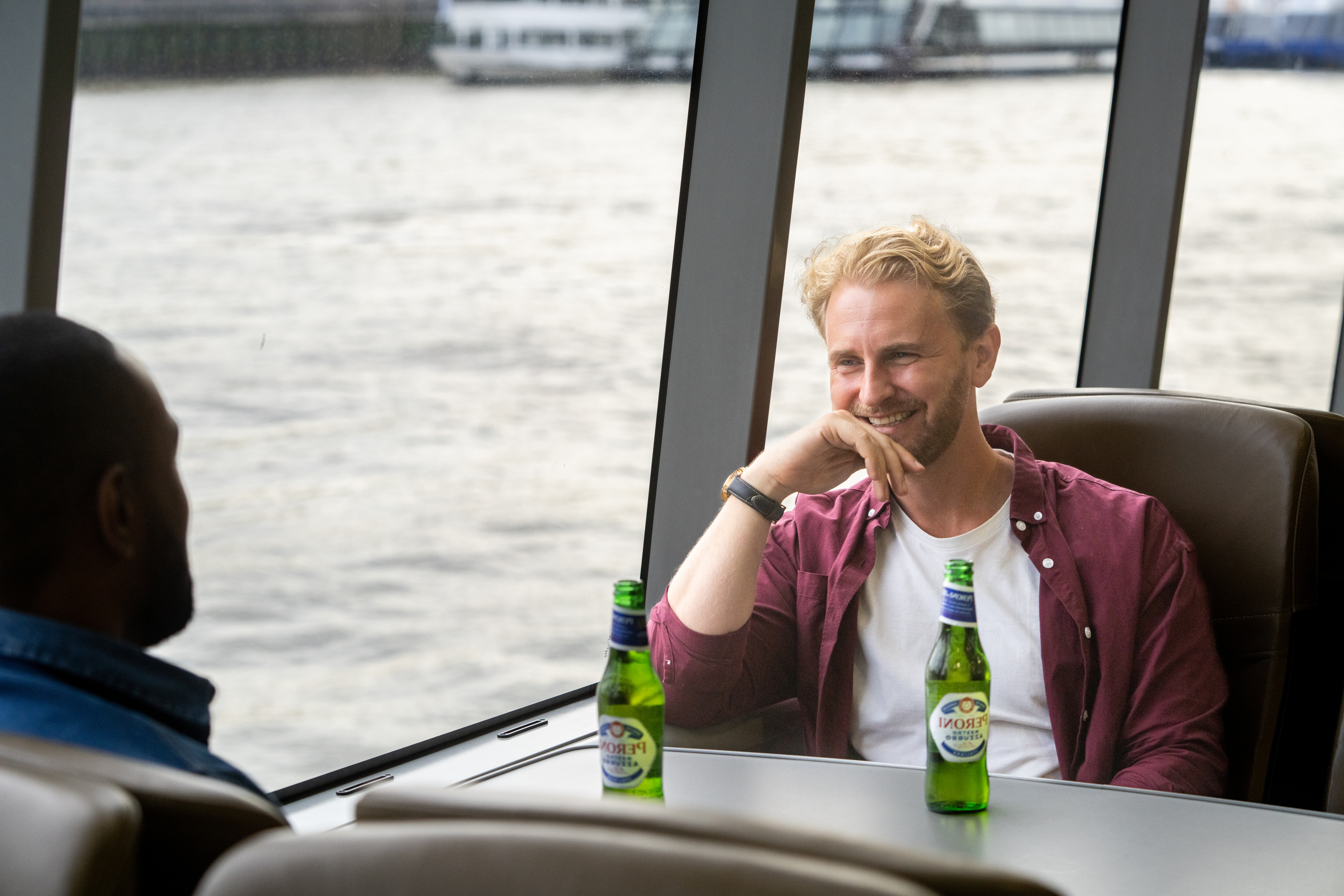 Two male friends drinking beer on board