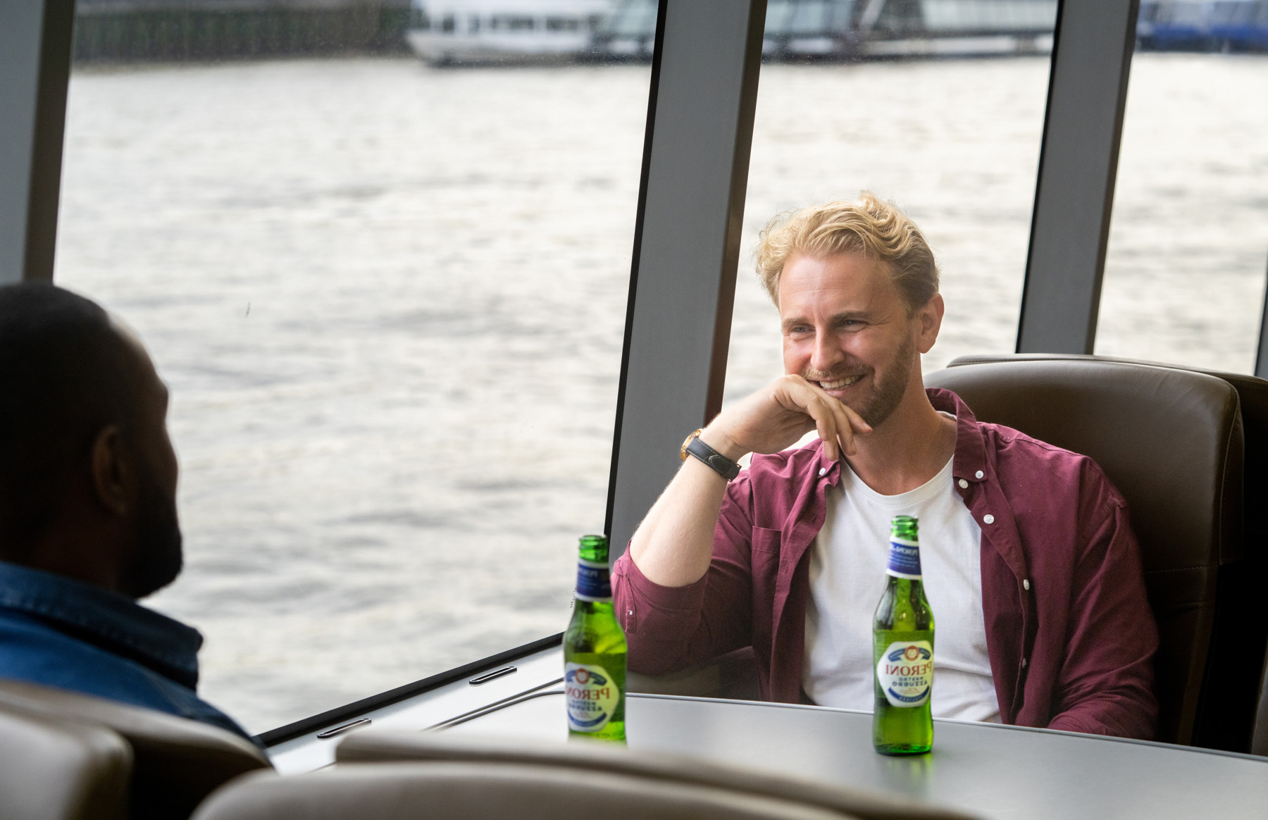 Two male friends drinking beer on board